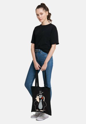 Schwarze Canvas-Tote-Tasche mit einem Cartoon-Maulwurf-Design in Weiß, Grau und Rot. Robuste Griffe; strukturierter Stoff.