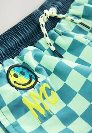 Kostkované plavky ve světlé modré a zelené barvě, s vyšitým smajlíkem a nápisem "NYC" ve žluté barvě, s páskem na stažení.