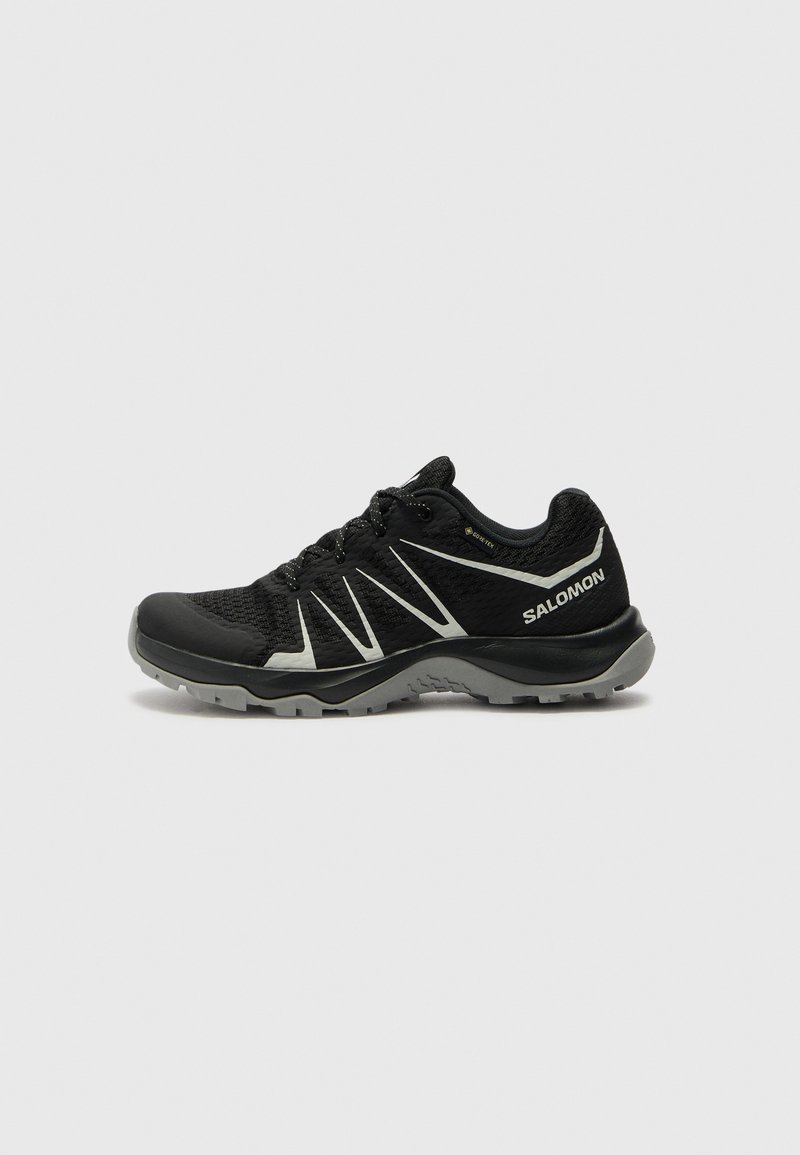 Schwarze Sport Schuhe mit einem atmungsaktiven Mesh-Obermaterial, strukturiertem Sohlenprofil, reflektierenden Akzenten und einer gepolsterten Zwischensohle für Komfort und Grip.