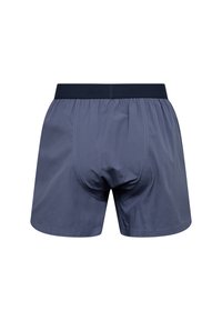 Námořnické modré boxerky vyrobené z hladké látky, s elastickým pasem a prošíváním. Mají volný střih a klasický design.