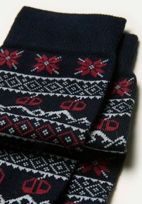 Merinovillapuserot, joissa on punaisia kukkia ja geometrisia kuvioita, pehmeä pinta ja raidoitettu varsiosa. Valkoiset korostukset tuovat esiin suunnittelua.