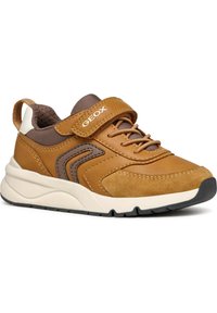 Zapatillas de cuero y ante marrón con paneles de malla, puntera redondeada, suela de goma y correa ajustable. Presenta detalles en marrón claro y texturizados.