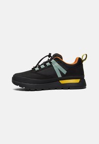 Baskets basses noires avec des brides bleu clair, une doublure intérieure orange, un détail jaune au talon et une fermeture à lacets à bascule sur une semelle robuste.