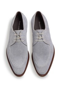 Scarpe da uomo di colore grigio chiaro realizzate in tessuto testurizzato con un design a rete. Presentano una punta affusolata e lacci color crema. Sole in pelle marrone.