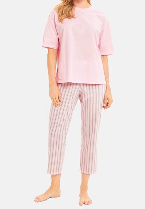Rosa Baumwoll-T-Shirt mit kurzen Ärmeln, kombiniert mit weißen Hosen, die vertikale Streifen in Pink, Blau und Lavendel aufweisen.