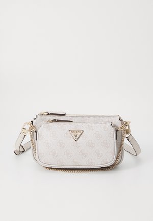 Lysebeige Guess crossbody taske med guldkæde-detalje, frontlynlåslomme og justerbar rem på hvid baggrund.