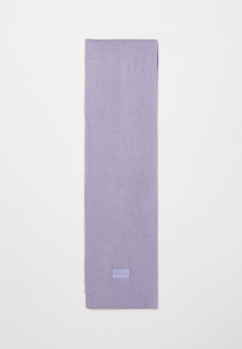Bufanda de lana morada con una textura acanalada, forma rectangular y una pequeña etiqueta con el nombre en uno de sus extremos.