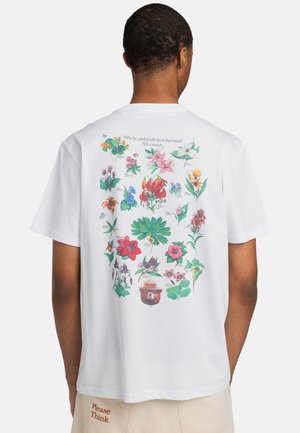 Weißes T-Shirt mit kurzen Ärmeln, auf der Rückseite mit einer bunten Blumenillustration, darüber Text und einem Bären-Icon in der Mitte unten.