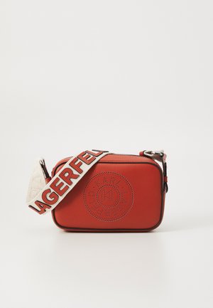 Red leather handbag with a rectangular shape, featuring perforated circular logo detail and a textured strap with "LAGERFELD" text.