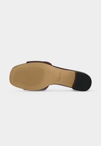 Semelle d'une sandale en cuir marron avec un bout carré, une semelle texturée, un embout de talon noir et le nom de la marque ALDO imprimé près de la voûte plantaire.