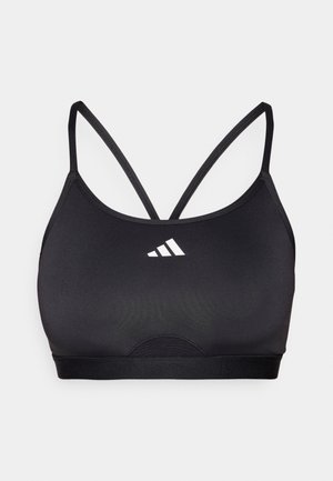 Černá sportovní podprsenka vyrobená z hladkého, elastického materiálu. Obsahuje tenké křížové ramínka a bílé logo na přední straně. Jednoduchý, funkční design.