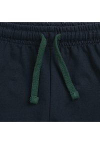 Pantalons de jogging bleu marine avec taille élastique, dotés d'un cordon vert en tissu texturé. Pas de poches supplémentaires ni de motifs.