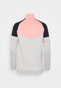 Athletic jacket with a high collar, featuring a pink upper section, black shoulders, and grey body, made of smooth fabric.