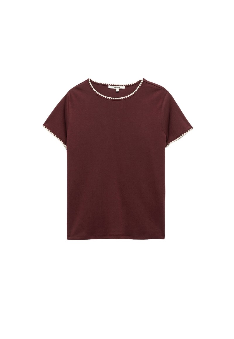 Burgundy kortärmad t-shirt i mjukt tyg, med en kontrasterande texturerad kant längs halsringningen och ärmarna.