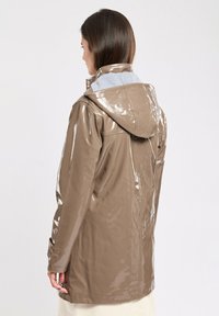 Giacca impermeabile marrone lucido con cappuccio e rivestimento grigio. Caratterizzata da maniche lunghe, bottoni a pressione e una texture liscia e brillante.