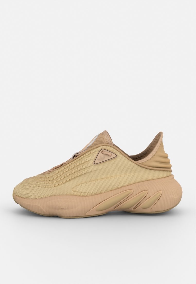 Scarpa con una toma beige testurizzata, design elegante e suola curvata. Presenta una punta arrotondata e un profilo minimalista con accenti sottili.