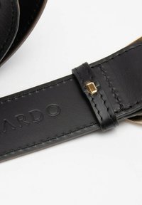 Čierny kožený opasok so stehovými detailmi, vyrazeným logom a zlatou kovovou príchuťou. Materiál sa zdá byť hladký s matným povrchom.