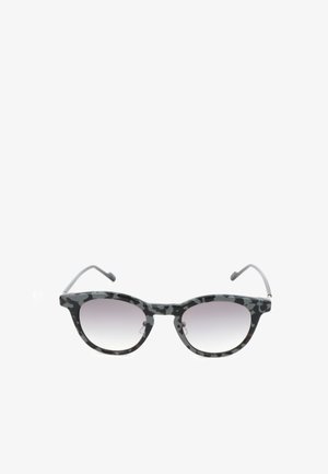 Occhiali da sole rotondi con motivo mimetico nero e grigio, con aste sottili nere e lenti grigie sfumate su sfondo bianco.