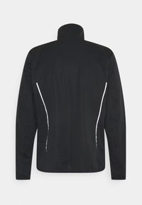 Schwarze Jacke mit hohem Kragen, ausgestattet mit weißen Akzenten an den Seiten und einer glatten Stofftextur. Geeignet für Freizeitmode.