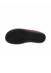 Sole in gomma nera con motivo a scanalature, attaccata a una scarpa rossa, mostrata dalla vista inferiore su uno sfondo bianco.