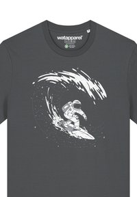 Grijze t-shirt met een witte graphic van een astronaut die op een golf surft, met sterren en ruimte-elementen in het ontwerp geïntegreerd.