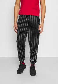 Karl Kani - SIGNATURE PINSTRIPE PANTS UNISEX - Tracksuit bottoms - black Thumbnail Image 1