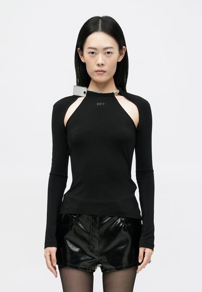 Black long-sleeve top with cut-out shoulder design, featuring a silver hardware accent. Smooth texture, fitted shape, and logo detail in front.