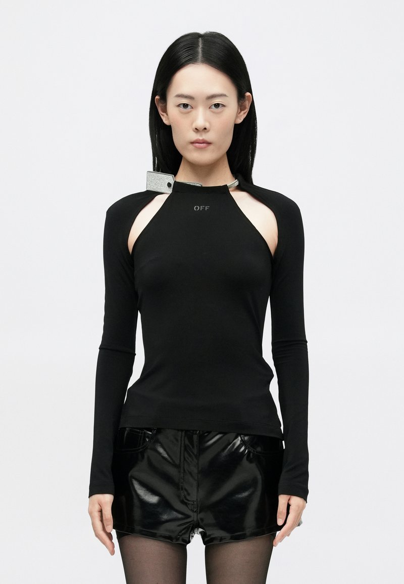 Fekete, hosszú ujjú felső, amelynek kivágott válldizájnja van, ezüst színű kiegészítővel. Sima textúra, testhezálló fazon és logó részlet elöl.