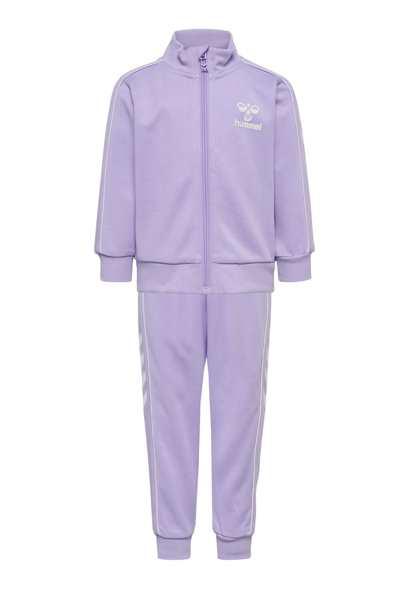 Ensemble de survêtement lilas avec veste zippée et pantalon assorti. Comprend des bandes blanches sur les manches et sur les côtés, fabriqué en tissu texturé doux.