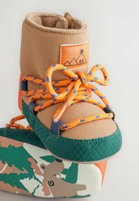 Braune wasserdichte Stiefel mit orangefarbenen und blauen Schnürsenkeln, Fleecefutter, grünem strukturiertem Sohle und gemusterten Details mit einem Bären und Bäumen.