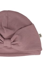 Beanie in cotone rosa con un dettaglio a fiocco annodato sulla parte anteriore e una piccola etichetta con logo. Tessuto morbido e forma arrotondata, adatto a diverse misure.