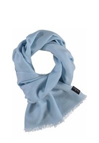 Bufanda de color azul claro hecha de tejido suave, con un borde desflecado y un brillo sutil, enrollada en forma de bucle. Etiqueta visible con el nombre de la marca.