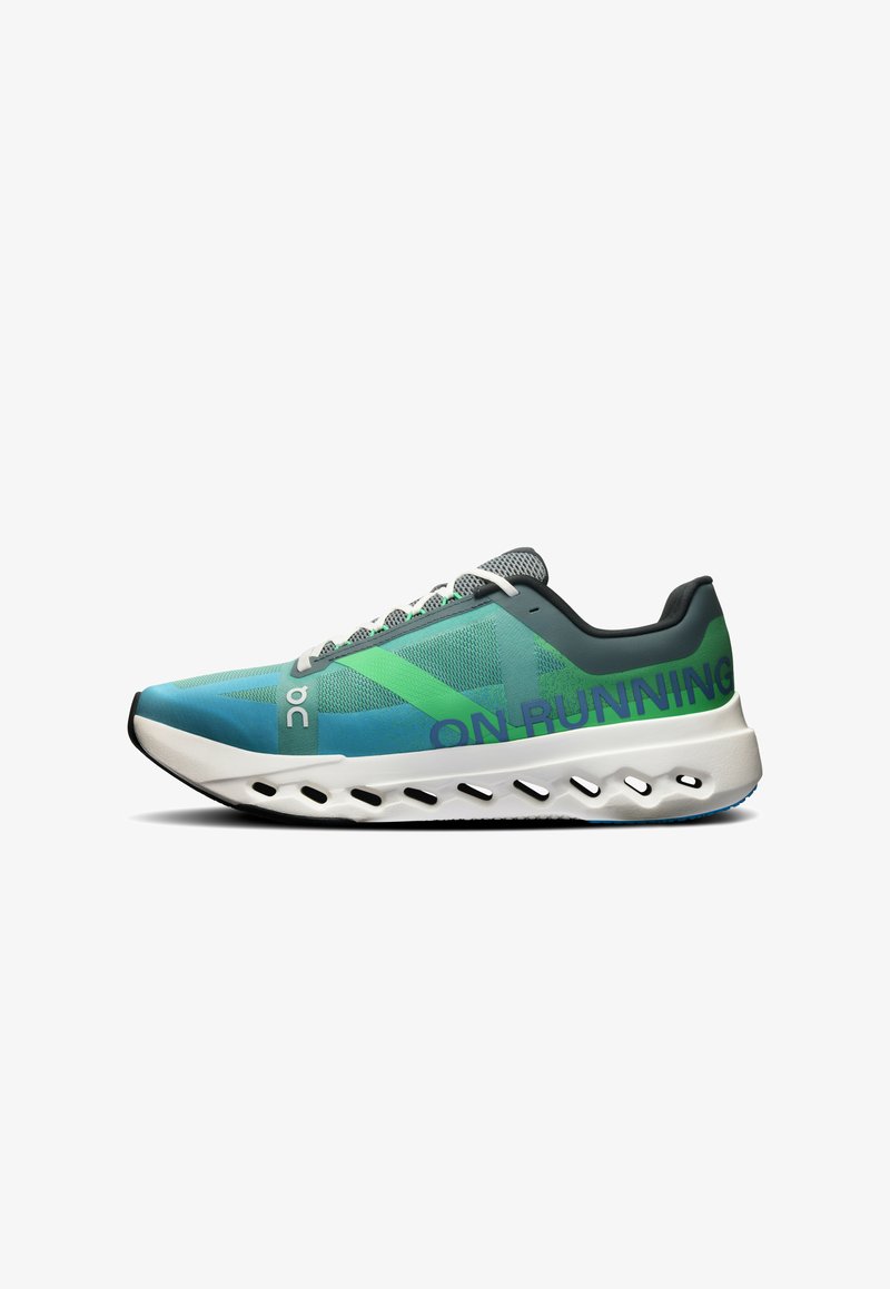 Running shoe with a blue and green mesh upper, grey accents, and a white textured sole featuring cut-out grooves for cushioning.
