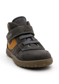 Scarpa alta in suede grigio con accenti marroni, cinturino in velcro e suola in gomma rotonda. Presenta dettagli cuciti e una parte superiore testurizzata.