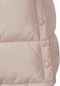 Ljust rosa puffjacka med en slät textur, horisontell quiltning och fem rundade, matchande knappar längs sömmen.