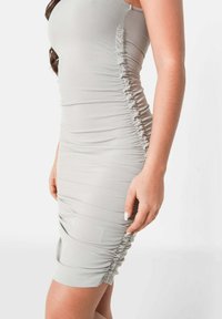 Abito bodycon grigio a coste con arricciature laterali, lunghezza al ginocchio, caratterizzato da una silhouette aderente e tessuto elastico per il comfort.