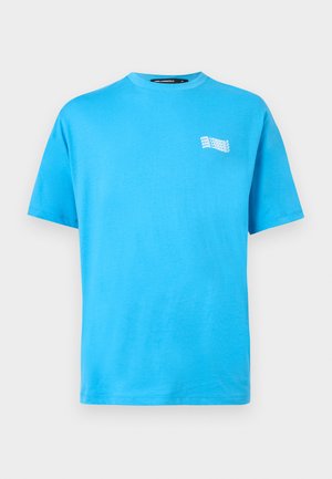 T-shirt bleu vif à manches courtes et col rond avec un petit texte blanc répété "KARL LAGERFELD" sur la poitrine gauche.