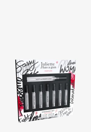 Discovery set of seven perfume vials in a black tray; features clear glass, black caps, and a white box with bold, colorful text and designs.