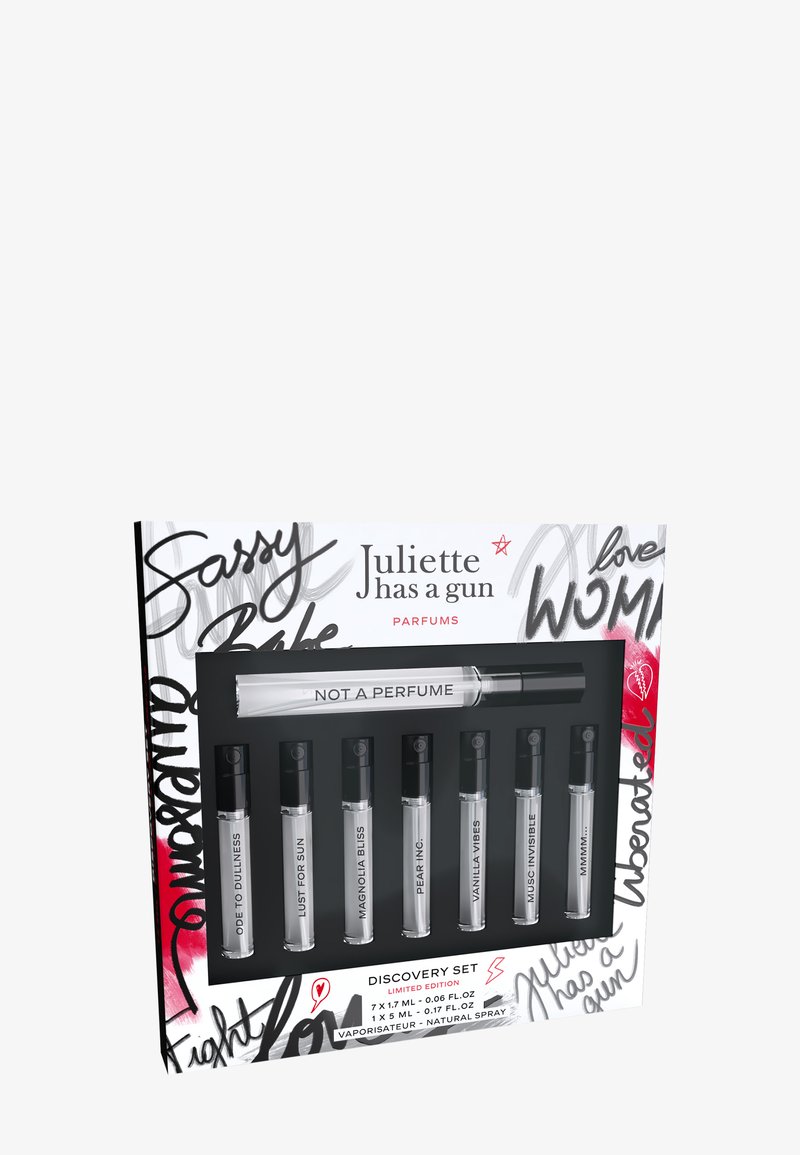 Coffret de découverte composé de sept flacons de parfum dans un plateau noir ; présente du verre transparent, des bouchons noirs et une boîte blanche avec un texte audacieux et coloré ainsi que des motifs.