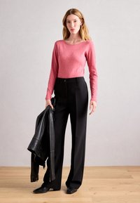 Ilgi piedurkņu, vienkrāsains rozā krekls, saskaņots ar melniem, augsto jostasvietu, plaša kāju biksēm. Modelis tur melnu ādas jaku, viņai ir taisni mati.