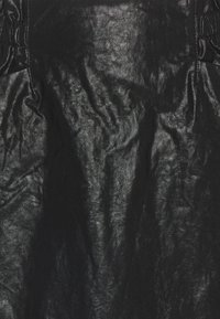 Zwart leren stof met een gestructureerd oppervlak, met subtiele rimpels en een zachte glans. Het materiaal lijkt duurzaam en flexibel.