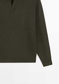 Maglione a maniche lunghe verde oliva scuro a coste con collo a V, mostrato disteso su uno sfondo bianco.