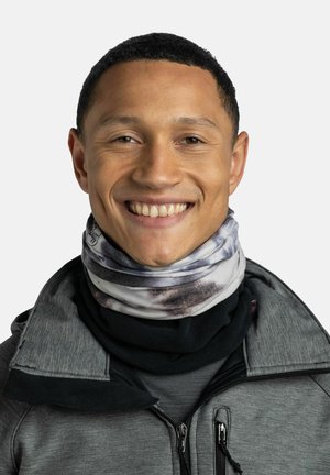 Gaiter de cuello con múltiples patrones en tejido suave; presenta tonos grises y negros con un diseño en espiral. Se lleva debajo del cuello de una chaqueta oscura.