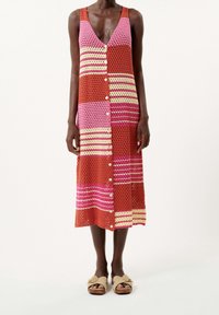 Vestito senza maniche a maglia in righe ruggine, rosa e giallo con dettagli a bottoni, caratterizzato da una scollatura a V e una lunghezza sotto il ginocchio.