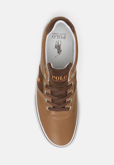 Καφέ δερμάτινος αθλητικός παπούτσι με καφέ σουέτ λεπτομέρειες, λευκή σόλα και καφέ κορδόνια. Διαθέτει λογότυπο Polo Ralph Lauren σε πορτοκαλί χρώμα.