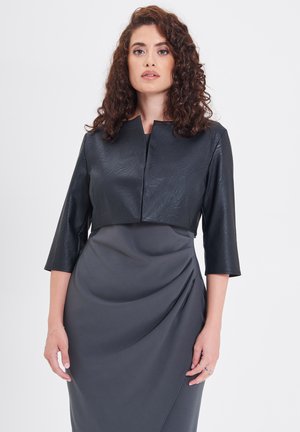 Schwarze kurze Jacke aus strukturiertem Material mit Dreiviertelärmeln. Darunter ein graues Wickelkleid mit glatter Stoffoberfläche.