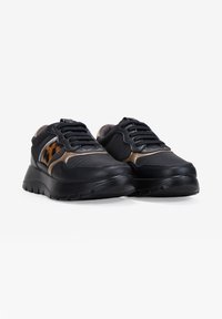 Zapatillas negras y marrones con parte superior de cuero texturizado, que presentan un acento de estampado de leopardo y una suela negra gruesa, con diseño de cordones.