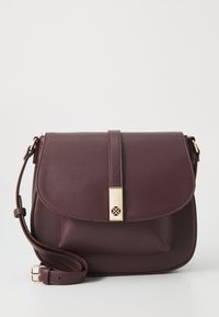 Sac en cuir bordeaux à porter en bandoulière avec une fermeture à rabat, des accessoires en métal doré, une bandoulière réglable et une surface texturée. Présente un design simple.