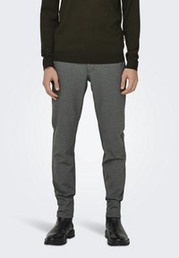 Grijs geweven broek met een tapered fit, voorzien van een subtiel patroon, zijzakken en een soepele textuur, gecombineerd met zwarte enkellaarsjes.