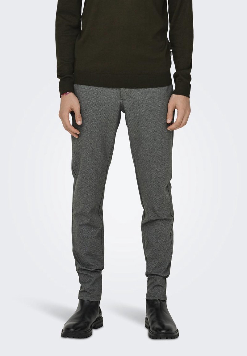 Grijs geweven broek met een tapered fit, voorzien van een subtiel patroon, zijzakken en een soepele textuur, gecombineerd met zwarte enkellaarsjes.